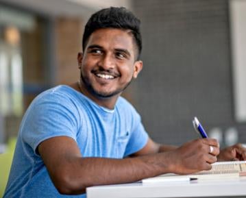Student at desk smiling