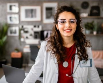 Woman wearing white lab coat and glasses