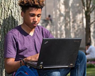 Student outside on laptop
